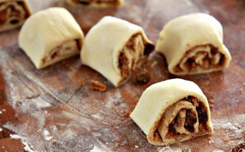 1. Этап. Булочки с орехами и изюмом: 3. Начиная с конца, плотно свернуть тесто в рулет. Обрезать края рулета около 1 см и выбросить. Нарезать рулет на 6 равных частей, каждый около 3,5 см в ширину.