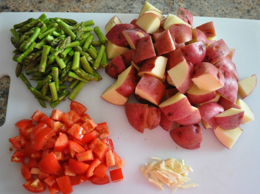 1. Этап. Куриная грудка с картошкой в духовке: 3. Далее можно заняться овощами. Молодой картофель достаточно просто вымыть как следует и нарезать. Измельчить немного спаржу и помидоры. Чеснок очистить и при желании пропустить через пресс, но можно тоже нарезать.