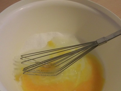 1. Этап. Оладьи из прокисшего молока: В чистую и сухую посуду с высокими стенками (например, подойдет миска) вбейте сырые куриные яйца. Добавьте к ним сахар и соль, хорошенько разотрите вилкой или же взбейте венчиком.