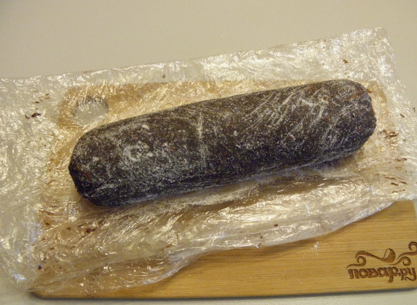 1. Этап. Сладкая колбаска: Готовую колбаску освободите от пленки. Присыпьте сахарной пудрой (пальцами вотрите пудру), придавая колбаске более натуральный вид. Десерт готов!