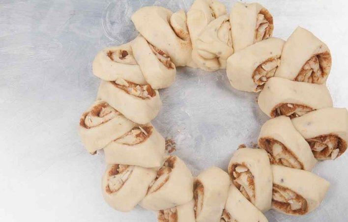 1. Этап. Шведский кекс: 6. Тесто будет похоже на венок, затем проделайте те же действия с другим рулетом. Оставьте тесто на 40 минут под пленкой. Смешайте желток со сливками и смажьте каждый веночек.