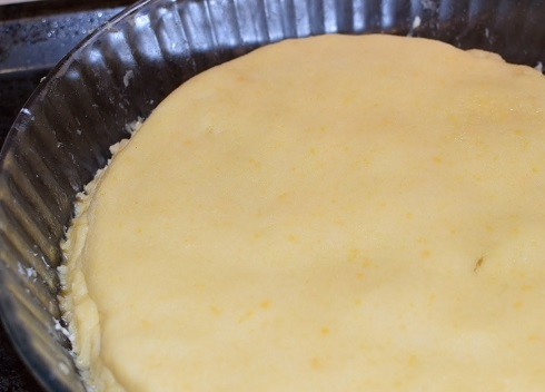 1. Этап. Карамельный яблочный пирог: Поверх яблок выложим раскатанное в пласт тесто, стараясь загнуть его по краю формы до дна.