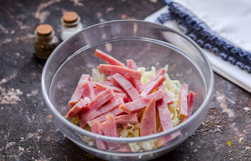1. Этап. Салат с ветчиной и китайской капустой: Ветчину нарежьте небольшими полосками или кубиками, добавьте ветчину в салат.