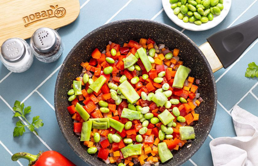 1. Этап. Паста орзо с овощами: Добавьте болгарский перец, стручковую фасоль и эдамаме. Если используете свежую фасоль, ее лучше предварительно отварить 2-3 минуты в кипящей воде, а заморозку можно добавлять сразу же. Обжарьте все еще 3-4 минуты.
