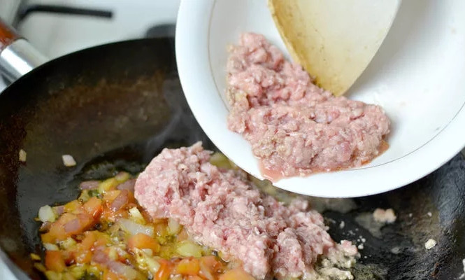 1. Этап. Спагетти с мясом: 2. Очистите и измельчите лук, чеснок. Выложите на сковороду и обжарьте до золотистого цвета. Вымойте, нарежьте небольшими кубиками помидоры. Обжарьте минут 5-6 на среднем огне. Добавьте фарш.