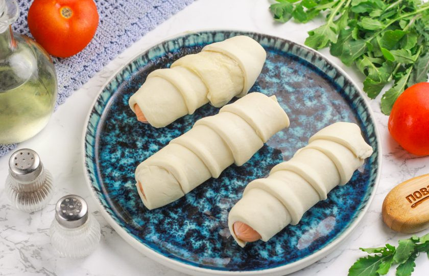 1. Этап. Сосиски в тесте в аэрогриле: Таким образом заверните в тесто все сосиски. За один раз выпекайте 3-4 сосиски в тесте в зависимости от величины чаши вашей техники, так как тесто еще вырастает в размере.