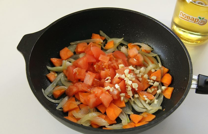 1. Этап. Суп Охотничий: У помидора сделайте крестообразный надрез ножом и подержите его пару минут в кипятке, после чего снимите шкурку, нарежьте мякоть кубиками и добавьте в сковороду к луку и моркови. На этом же этапе добавьте измельченный ножом чеснок.