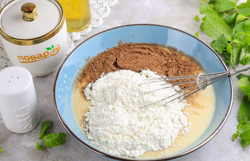 1. Этап. Шоколадные оладьи на кефире: Всыпьте пшеничную муку и какао-порошок, аккуратно вмешайте.