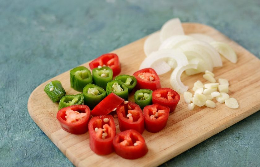 1. Этап. Острый перец на зиму: Острый перец нарежьте кружочками, репчатый лук полукольцами, а зубчики чеснока пластинами.