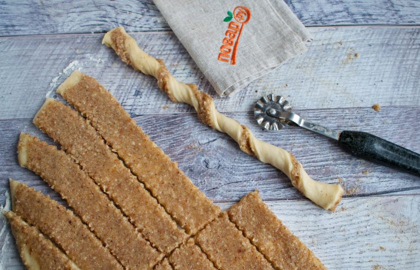 1. Этап. Плюшки с миндалем: Рабочую поверхность посыпьте мукой. Раскатайте тесто в прямоугольный пласт толщиной 0,5 см. Распределите по всему тесту начинку ровным слоем. Разрежьте тесто с начинкой на небольшие равные по ширине полоски. Заверните их спиралькой.