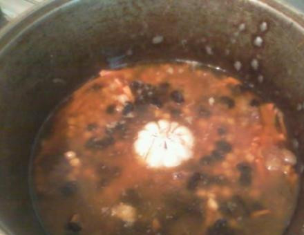 1. Этап. Плов с бараньими ребрышками: 4. Огонь убавляем, заливаем воды (примерно на сантиметр над мясом), и добавим кишмиш, горох, чеснок, зиру и прочие специи. Закрываем крышкой, пусть тушится.