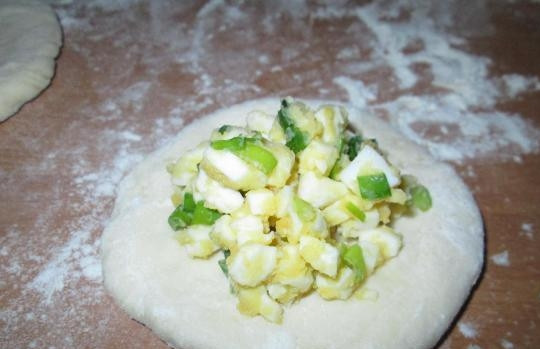 1. Этап. Пирожки с сайрой: Разогрейте духовку до 200 градусов. Раскатайте каждый кусочек в лепёшку, в центр которой уложите по 2 чайные ложки начинки.