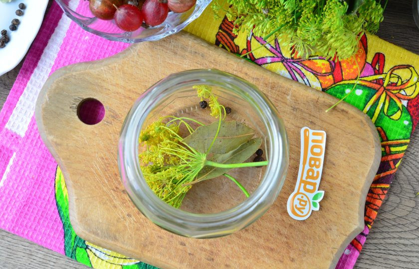 1. Этап. Помидоры с крыжовником на зиму: На дно чистой простерилизованной банки выложите специи: зонтики укропа, лавровый лист, перец горошком.