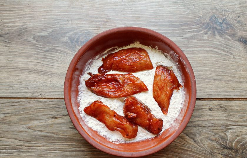 1. Этап. Куриные нагетсы в кукурузной панировке в духовке: Замаринованные кусочки полностью обваляйте в муке.