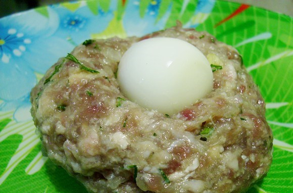 1. Этап. Зразы на пару в мультиварке: 3. Из фарша лепим котлетки, внутрь помещаем яйцо. Раскатываем в руках так, чтобы яйцо нигде не выглядывало.