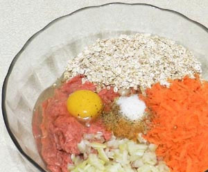 1. Этап. Тефтели из курицы в духовке: В куриный фарш добавить порезанный лук, яйцо, натертую морковь, овсяные хлопья, соль, перец.