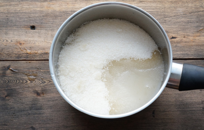 1. Этап. Карамельное яблоко: Положите яблоки в морозилку. Возьмите сотейник с высокими стенками. Насыпьте туда сахар, влейте воду и кукурузный сироп.