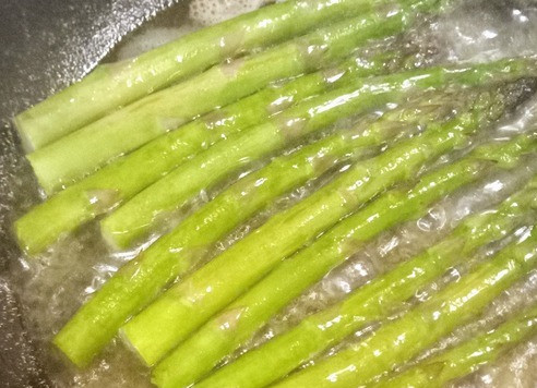 1. Этап. Морской окунь со спаржей: На сковороде растопить половину сливочного масла, выложить спаржу и готовить 8 минут.