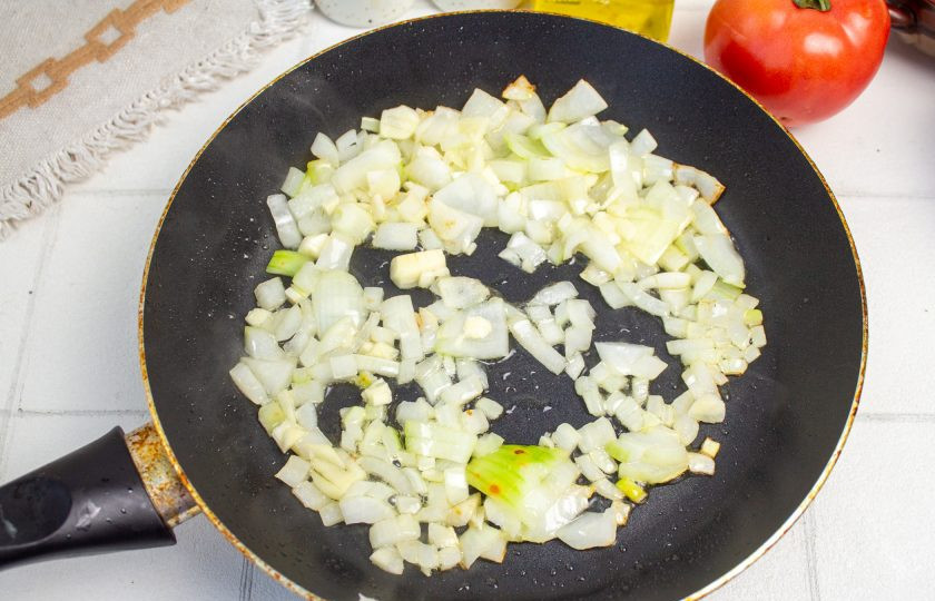 1. Этап. Лазанья с помидорами и сыром: Лук и чеснок нарежьте мелко и обжарьте до мягкости на растительном масле.