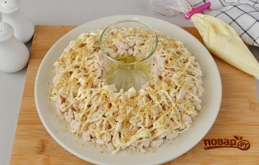 1. Этап. Салат Гранатовый браслет с курицей и яблоком: Смажьте куриное филе майонезом и щедро посыпьте рублеными орехами.