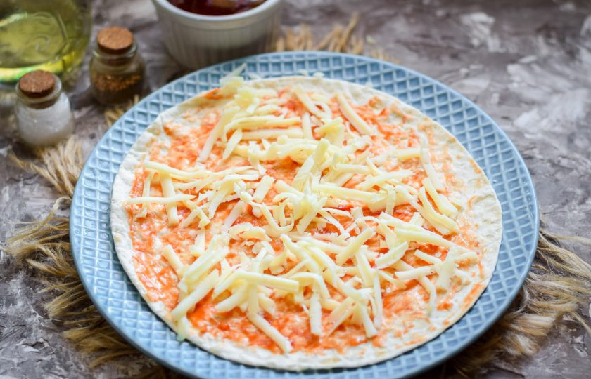1. Этап. Пицца на сковороде за 15 минут: Посыпьте лаваш тертым твердым сыром.