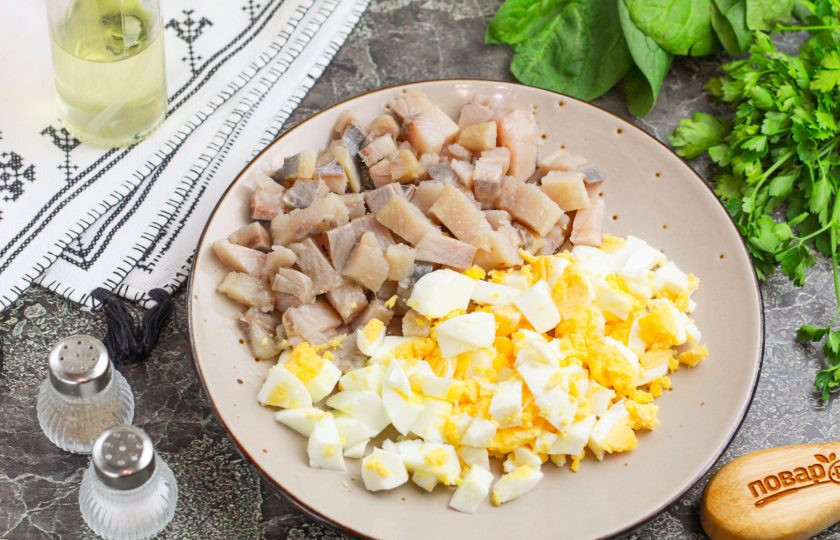 1. Этап. Селедочное масло классический рецепт: Очистите отварные куриные яйца от скорлупы, промойте в воде. Нарежьте кубиками. Филе сельди тоже нарежьте кубиками, удалите косточки, если они присутствуют.