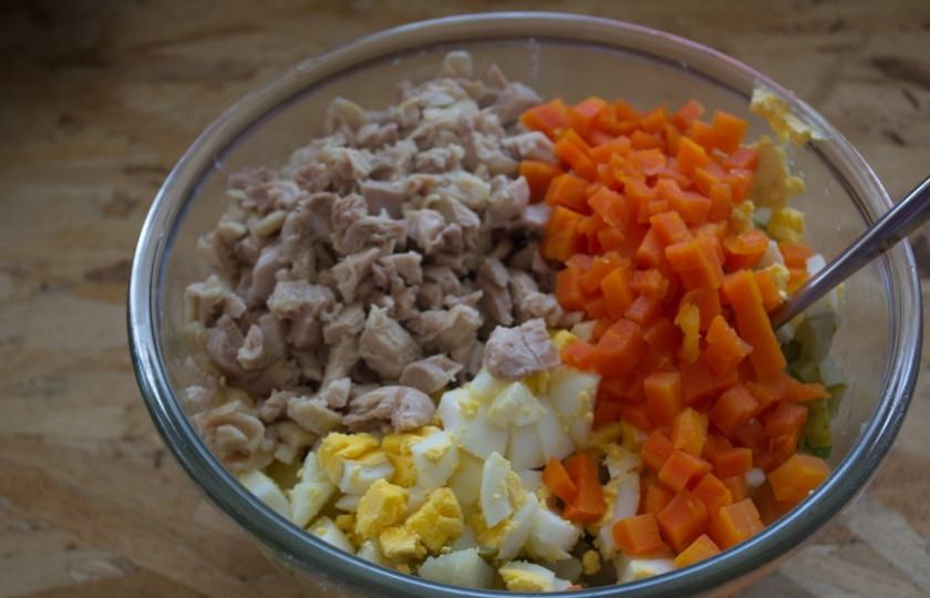 1. Этап. Салат Оливье классический рецепт: Морковь отварите. Очистите и нарежьте кубиком. Яйца отварные и куриное мясо тоже нарежьте мелко.