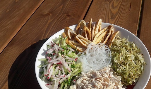 1. Этап. Кукси-корейский холодный суп: В суповую тарелку для подачи уложить курицу, свежие овощи, обжаренную капусту, яичный блинчик (порезанный наискосок) и фунчозу.