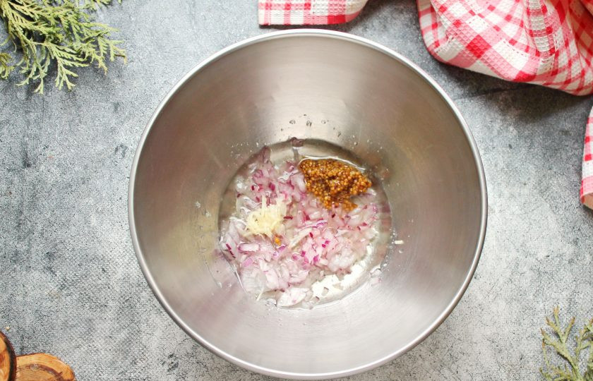 1. Этап. Салат с креветками и авокадо и яблоком: Чеснок натрите на средней терке, красный лук мелко порежьте. Выложите в миску овощи, горчицу, влейте растительное масло, сок лимона, посолите и все перемешайте.