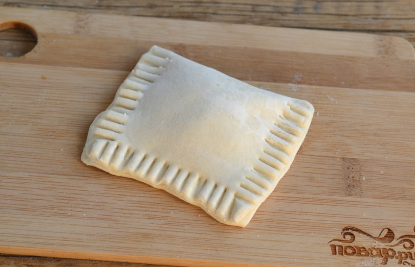 1. Этап. Слойки с вареньем из слоеного теста: Накройте варенье второй половиной теста, скрепите края с помощью вилки.