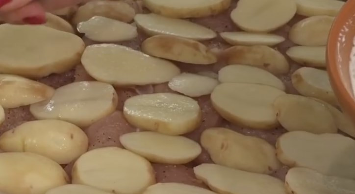 1. Этап. Куриная грудка под кабачками: 3. Почищенную картошку нарежьте ломтиками и выложите на мясо. Посолите.