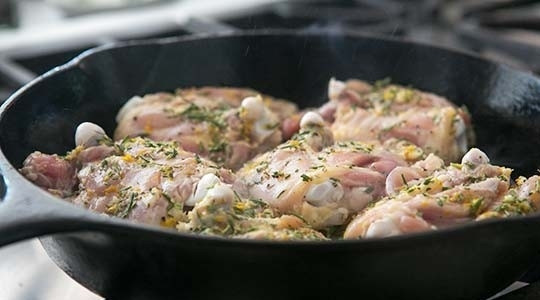 1. Этап. Куриные бедра с лимоном и розмарином: 3. Разогрейте сковороду с оставшимся оливковым маслом и выложите бедра кожей вниз, обжарьте до золотистой корочки.