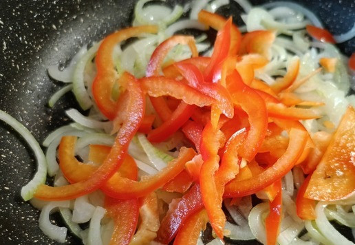 1. Этап. Индейка со сладким перцем и вином: Обжарить нарезанный лук до мягкости. Добавить нарезанный соломкой сладкий перец. Обжаривать еще минуты 2-3 минуты.