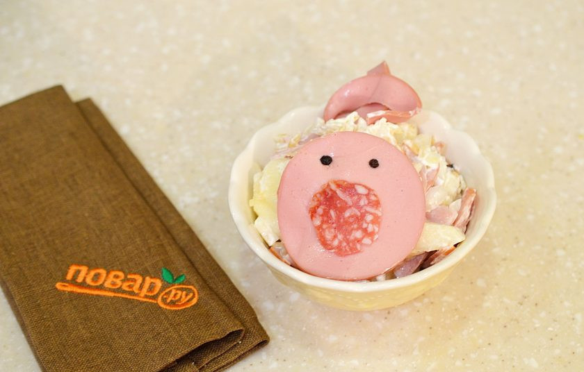 1. Этап. Салат на Новый год Свиньи: 7. Из вареной колбасы сделаете мордочку свиньи, из копченой пятачок. Сделайте хвостик и ушки.