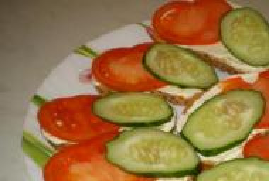 1. Этап. Бутерброды с консервированной рыбой: Уложите на хлеб ломтик помидора и огурца.