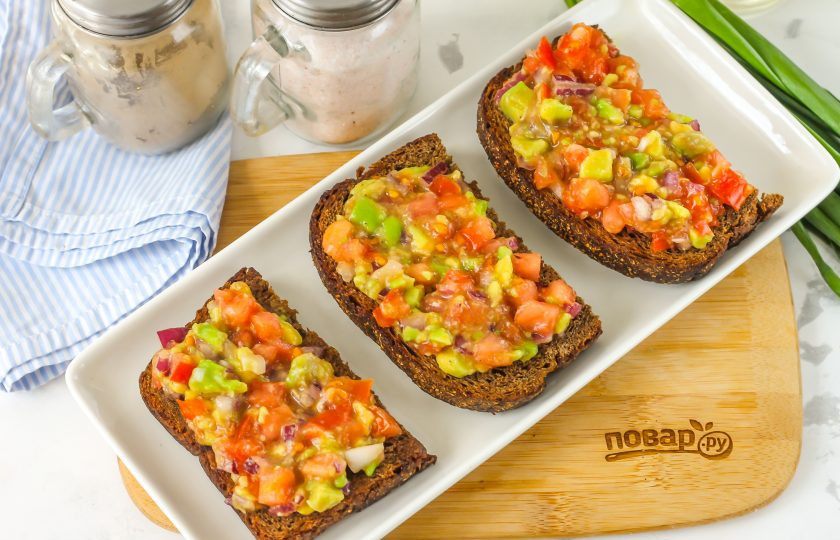 1. Этап. Брускетта с гуакамоле и креветками: Выложите гуакамоле на ломтики хлеба, равномерно распределите его по ним.