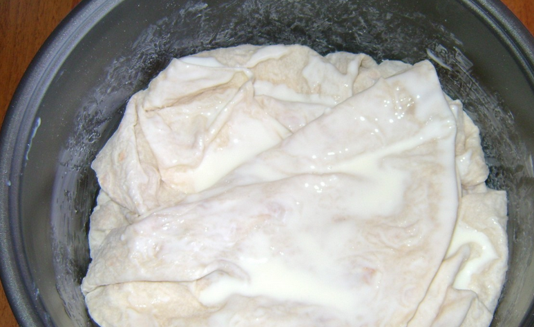 1. Этап. Ачма с брынзой: Далее чередуем слои, пока не закончатся ингредиенты. Накрываем последний слой краями основного лаваша. Заливаем остатками кефирно-яичной смеси.