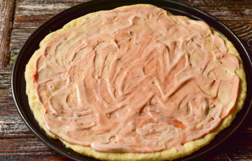 1. Этап. Пицца с креветками и рукколой: Выложите тесто на противень, хорошо придавите его руками. Смажьте кетчупом и майонезом.