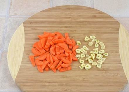 1. Этап. Куриный рулет в желе: 2. Морковь очистить, вымыть и нарезать маленькими кусочками. Лучше использовать небольшую морковь или половину средней. Чеснок очистить и также измельчить.