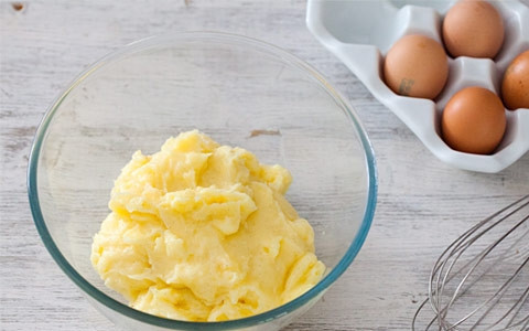 1. Этап. Начинка для бисквитного торта: Для крема просейте оба крахмала, добавьте сахарную пудру и семена стручка ванили, перемешайте. Добавьте желтки, перемешайте смесь венчиком. Доведите до кипения молоко со стручком ванили. Процедите, слегка охладите и, постепенно вливая в желтковую смесь, интенсивно перемешивайте. Поставьте крем на слабый огонь и варите до загустения, постоянно помешивая. Выключите, перелейте крем в миску и дайте остыть под пищевой пленкой, прилегающей к поверхности крема.