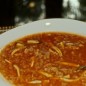 Суп томатный с морепродуктами Лук нарезать, морковь натереть на терке, все обжарить на растительном масле до золотистого цвета. На помидорах сделать крестообразные надрезы, ошпарить кипятком, снять кожицу, натереть на терке и добавить к луку (если честно, я с кипятком и снятием кожицы не вожусь: крестообразно надрезала, по краям надреза кожицу отогнула и сразу на терку - получается, мякоть натерла, а кожица в руке осталась). посолить, поперчить, тушить 5-7 минут. переложить в кастрюльку. Рис с карри (можно добавлять любые другие специи на ваш вкус) обжарить на сковороде в масле до золотистого цвета. добавить уксус, 2-3 ст. ложки воды и потушить минут 5. Вместо уксуса с водой можно (даже предпочтительнее) использовать белое вино - более нежный вкус получается. переложить в кастрюльку. Добавить в кастрюльку томатный сок, поллитра или литр воды (смотря какой густоты суп вы хотите получить), довести до кипения и варить 10 минут. Морепродукты вымыть, обсушить, добавить в суп и варить еще 10 минут. если необходимо, подсолить. добавить зелень по вкусу. Приятного аппетита!