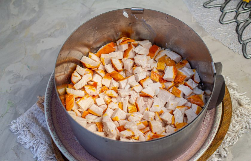 1. Этап. Салат с копченой курицей, черносливом и грецкими орехами: Куриное копченое мясо нарежьте небольшим кубиком и выложите на рис.