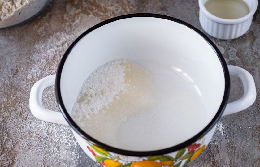 1. Этап. Домашняя халва: В кастрюльку высыпите сахар, ванильный сахар и добавьте воду. Проварите на среднем огне сироп до полного растворения сахара.