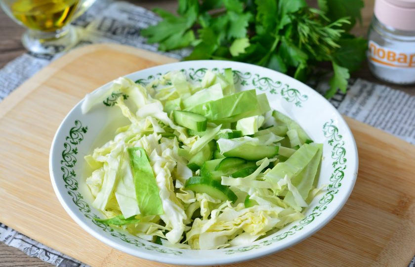 1. Этап. Салат с курицей и белокочанной капустой: Смешайте в емкости капусту и огурцы.