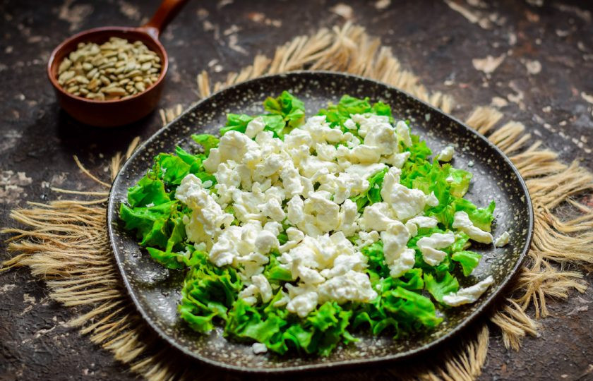 1. Этап. Зеленый салат с киви: Поверх салата разложите зерновой творог, также вы можете использовать любой вид разносольного сыра.