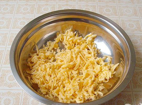 1. Этап. Курица в сметанно-сырном соусе: 4. На терку натираем сыр, для того, чтобы он хорошо терся, его лучше предварительно заморозить. Когда пройдет тридцать минут, противень из духовки вынимаем и посыпаем окорочка тертым сыром. Минут на десять-пятнадцать ставим противень обратно в духовой шкаф.