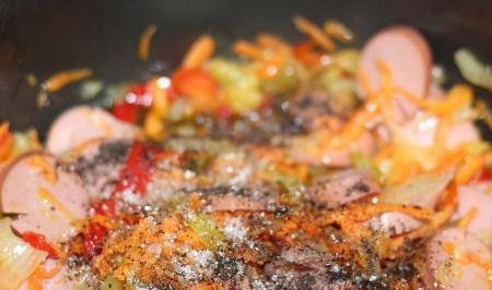 1. Этап. Капуста с сардельками в мультиварке: Сардельки очищаем от кожицы и нарезаем кусочками, кольцами, кубиками (как вам удобнее) и отправляем к овощам. Добавляем молотый черный перец и пол чайной ложки сахара.