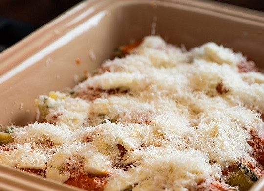 1. Этап. Макароны, фаршированные сыром и шпинатом: 4. Присыпьте сверху тертым пармезаном и отправьте противень в разогретую до 180 градусов духовку. Запекайте блюдо минут 40 до румяности.