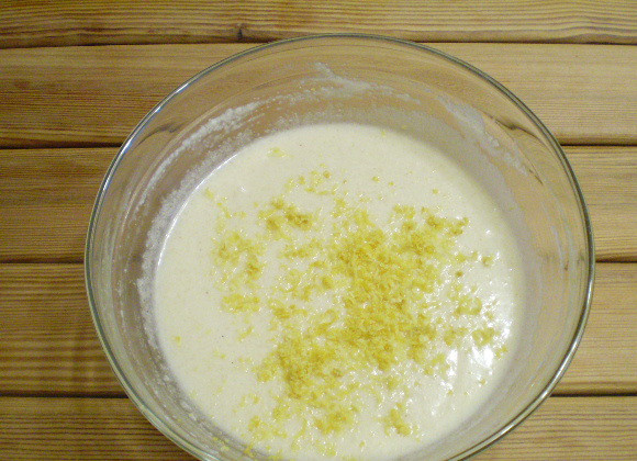 1. Этап. Лимонный манник: Возьмите лимон и мелкую терку. Снимите теркой кожуру, добавьте цедру в тесто. Перемешайте.