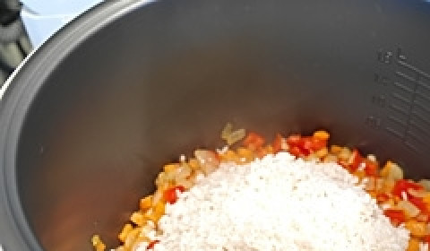 1. Этап. Рис с овощами в мультиварке: В чашу мультиварки налить растительное масло. Добавить промытый рис, нарезанные овощи - болгарский перец, морковь, лук. Добавить зеленый горошек и кукурузу. Количество горошка и кукурузы регулируйте по своему вкусу.